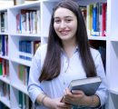 Woman holding book in library